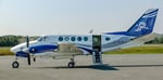 Un avion King Air A100 stationné sur le tarmac par une journée d’été.