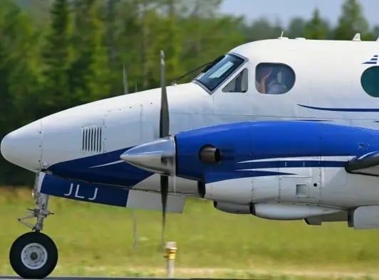 L’avant d'un avion King Air A100 de Propair en déplacement sur le tarmac par une journée d’été.