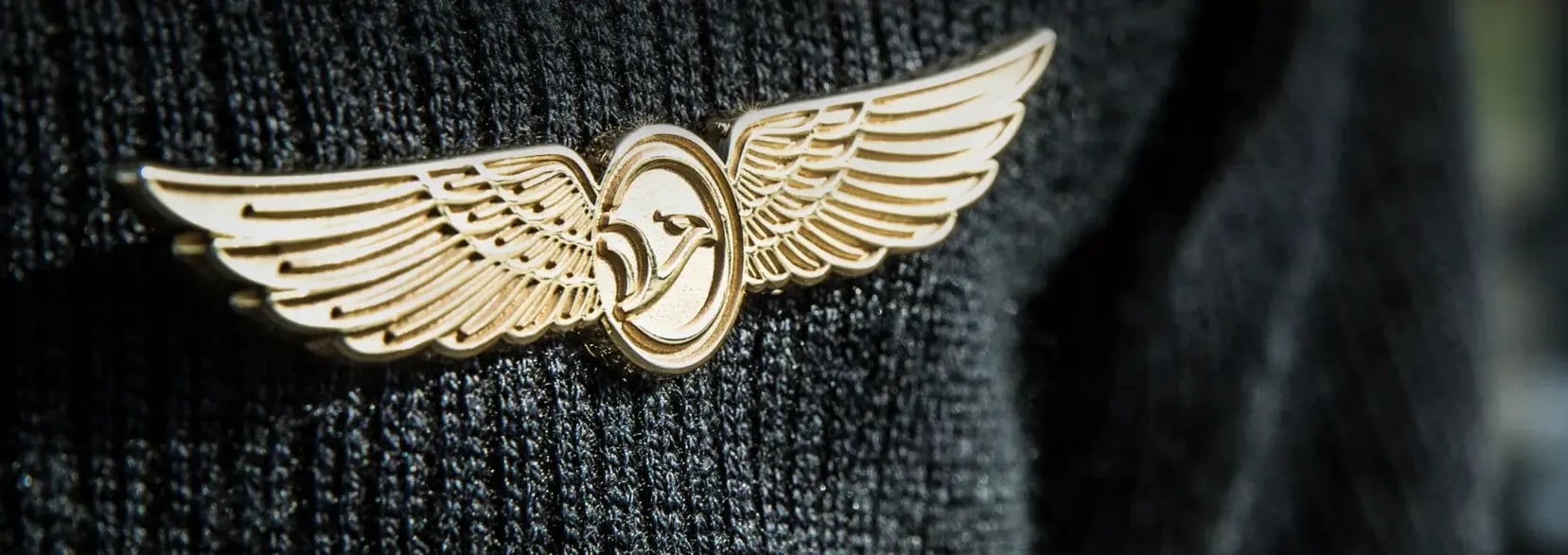 A pilot’s wings pin with the Grondair logo, pinned on a student’s blazer